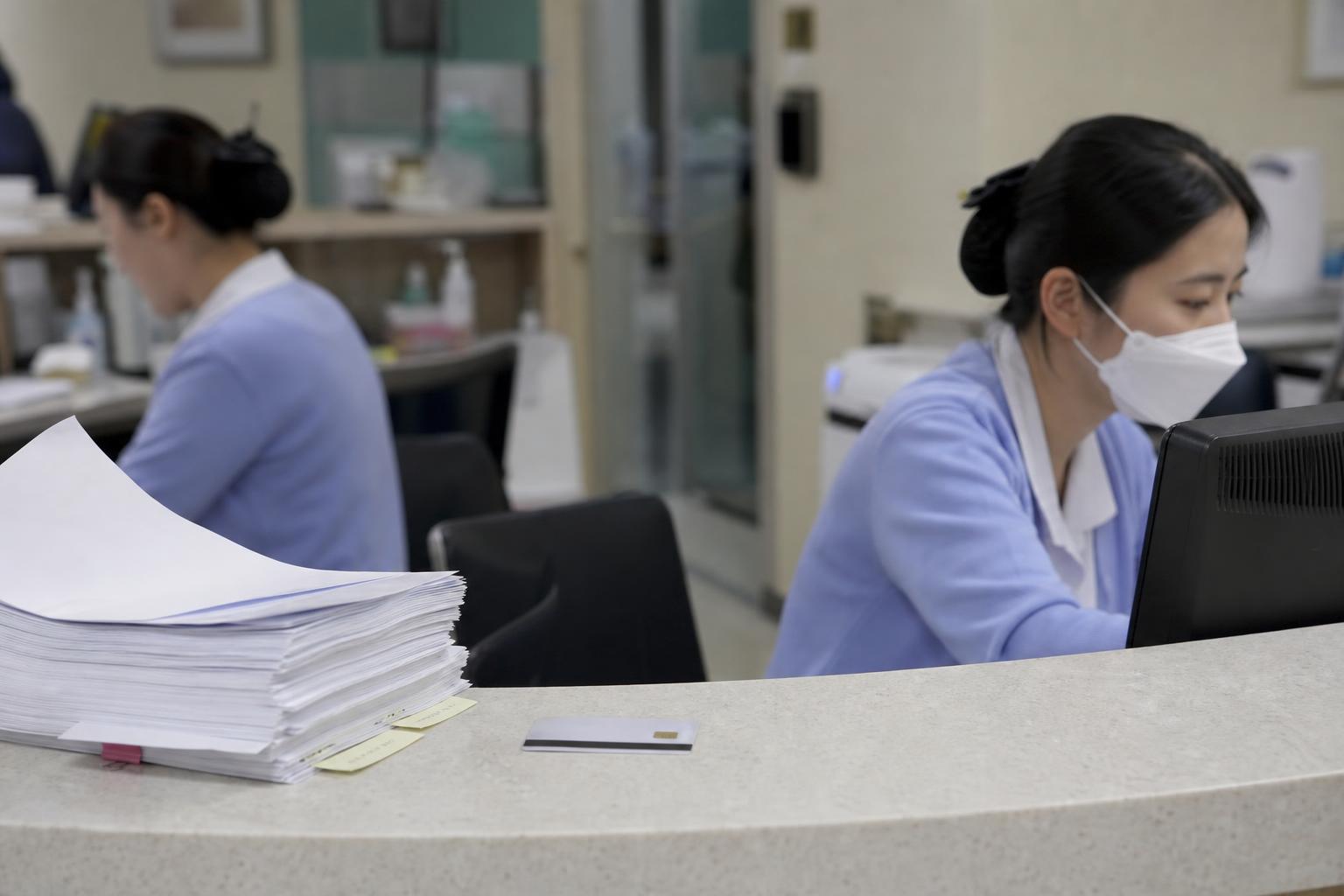 서류와 건강보험증 카드가 놓인 접수 창구 탁자