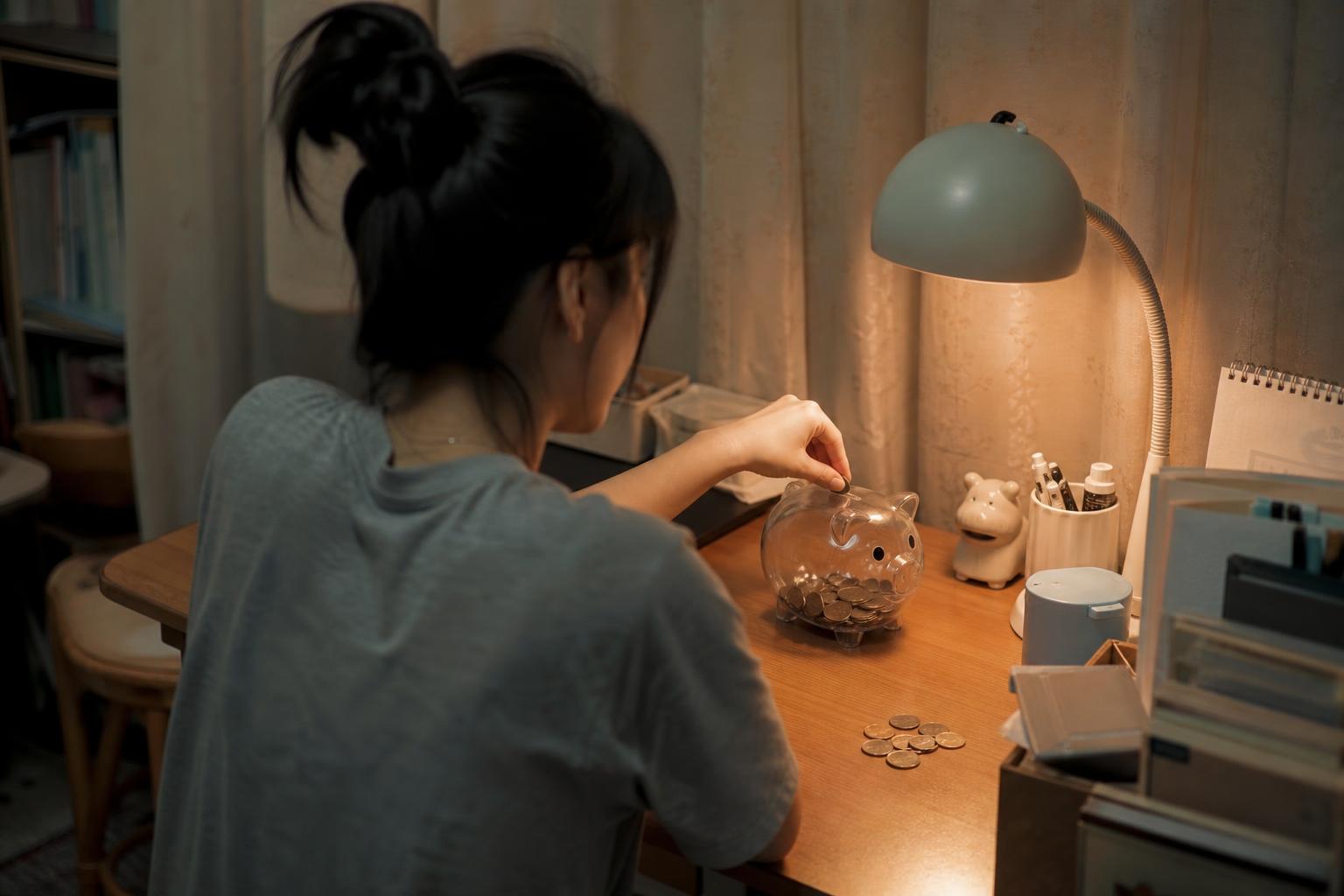 저금통에 동전을 넣는 사람의 뒷모습