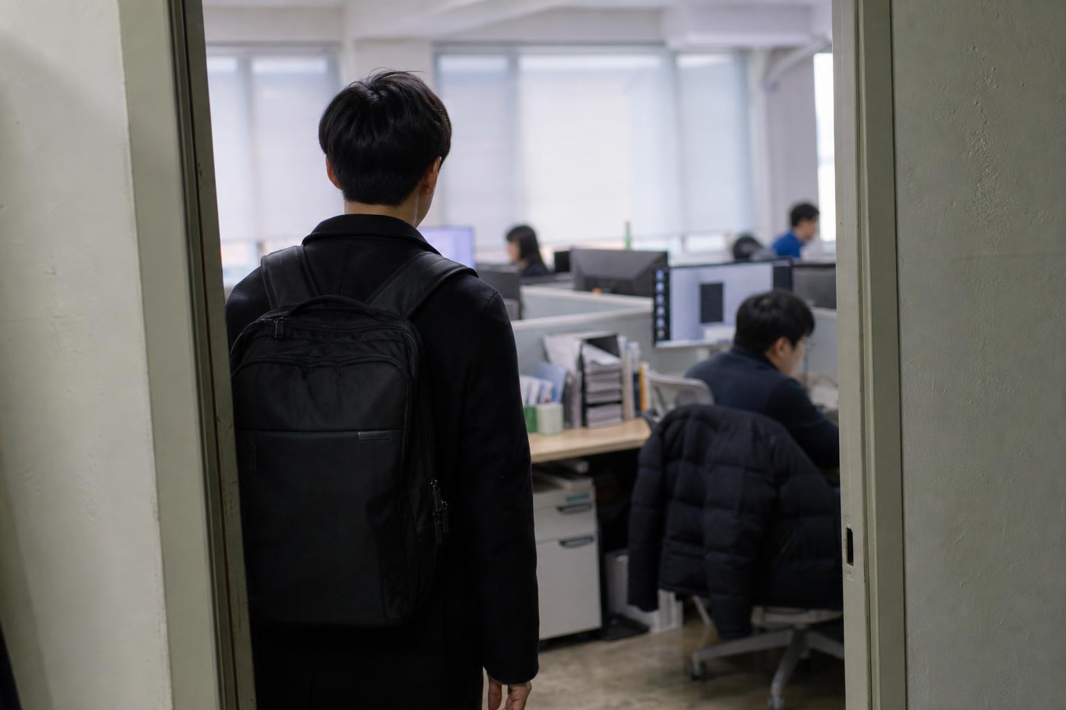 이른 아침 사무실로 들어서는 직장인의 뒷모습