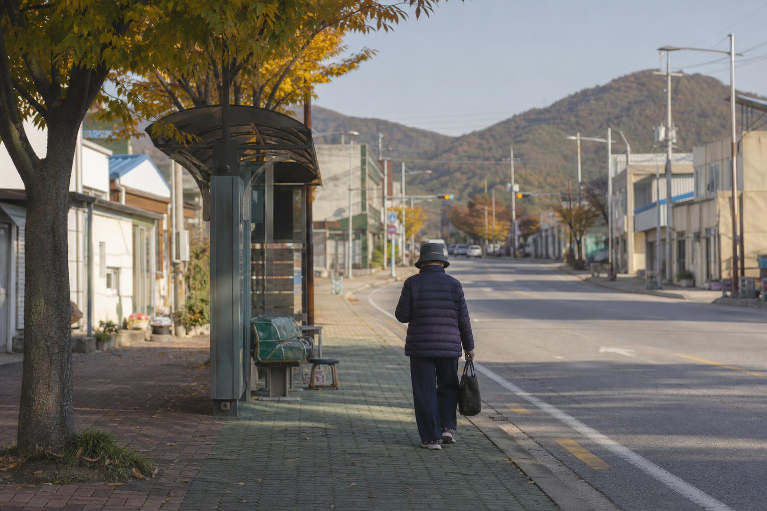 맑은 가을 아침, 낮은 건물과 버스 정류장이 있는 한적한 지방 소도시 거리