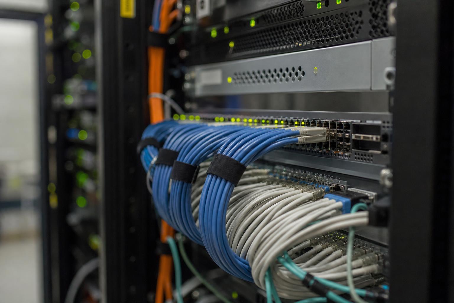 서버 랙 사이 통로에서 케이블이 정리된 모습의 가까운 장면