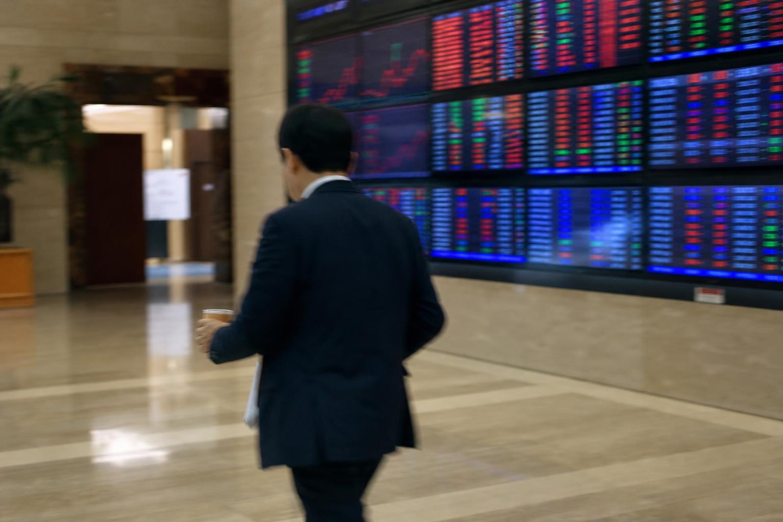증권사 객장 전광판 앞을 지나는 사람의 뒷모습
