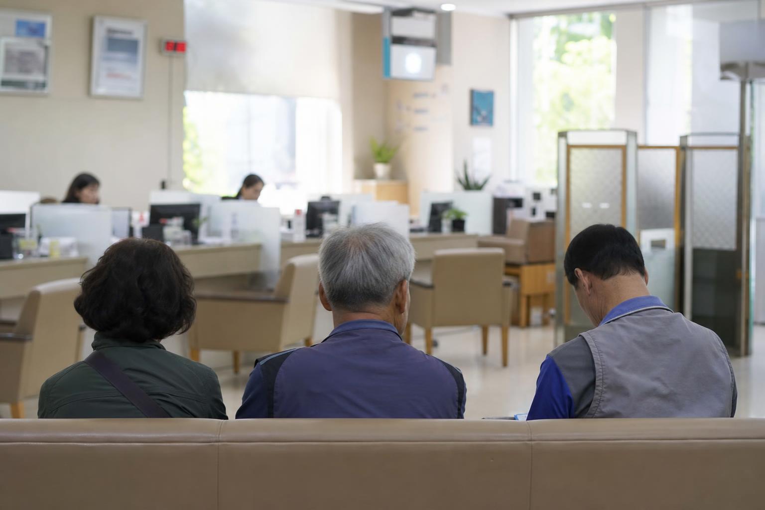 한국의 은행 창구 앞 의자에 사람들이 앉아 순서를 기다리는 오후 풍경